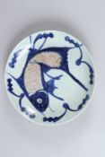 A CHINESE CIRCULAR PORCELAIN DISH, painted with a large fish. 25.5cms diameter.