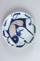 A CHINESE CIRCULAR PORCELAIN DISH, painted with a large fish. 25.5cms diameter.