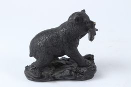 A SMALL BRONZE FIGURE OF A BEAR WITH A FISH IN ITS MOUTH. 15cms long.