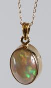 A 9CT YELLOW GOLD AND FINE OPAL OVAL SHAPE PENDANT AND CHAIN.