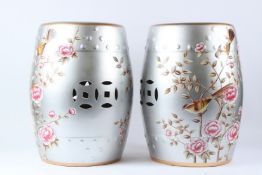 A PAIR OF CHINESE STYLE PORCELAIN BARREL SEATS, silver ground, decorated with birds and flowers.