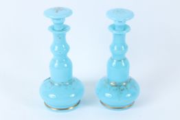 A PAIR OF 19TH CENTURY FRENCH BLUE OPALINE GLASS BOTTLES AND STOPPERS, with gilt decoration. 18cms