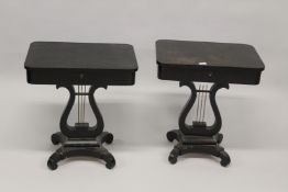 A PAIR OF REGENCY STYLE EBONISED WORK TABLES, with rising tops, compartmented interior on lyre