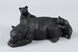 A BRONZE MODEL OF A RECUMBENT BEAR AND TWO PLAYFUL CUBS. 23cms long.