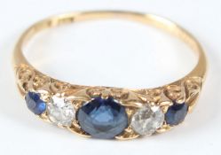 A YELLOW METAL, DIAMOND AND SAPPHIRE FIVE STONE RING.