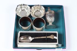 A GROUP OF SILVER ITEMS, to include a pepperette, pair of salts, pair of napkin rings and a boxed