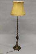 A BRASS FLOOR STANDING LAMP, with turned column on an hexagonal shape base, with shade. 157cms high,