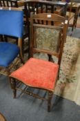 An unusual Edwardian occasional chair with engraved metal back panel.
