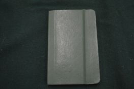 A Moleskine green leather notebook.