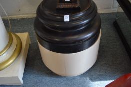 A pair of ebonised circular stands on cream painted bases.