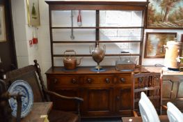 A 19th century oak dresser with triple delft rack above a base with three frieze drawers and two