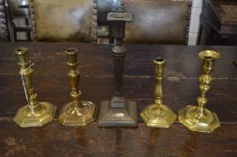 Four early brass candlesticks and a later candlestick.