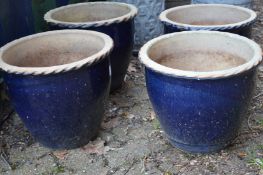 A set of four blue glazed terracotta planters.