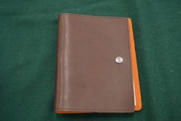 A William Hannah brown leather bound notebook.
