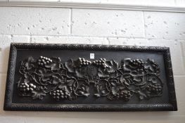 A carved wood panel depicting grapes and vine with crest, dated 1916.