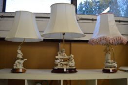 Three decorative figural table lamps and shades.