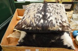 Two animal skin cushions and various animal skins.