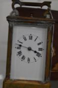 A brass carriage clock with leather travelling case (faults).