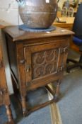Small reproduction oak single door cupboard on turned supports.