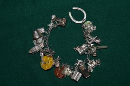 Charm bracelet containing silver and other charms.