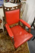 A pair of Arts and Crafts oak open armchairs with red leather cloth upholstery together with a
