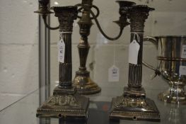 A pair of plated corinthian column candlesticks, bases drilled.