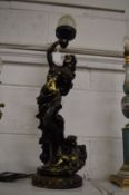 A decorative figural table lamp with flaming torch shade.