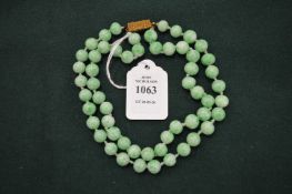 A mottled jade bead necklace with decorative clasp.