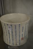 A large Chinese brush pot decorated with calligraphy.