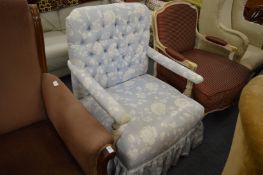 A floral upholstered armchair with painted frame.