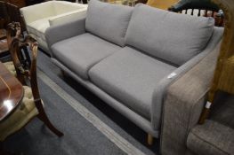 A modern grey upholstered two seater settee.