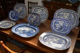 A collection of nine blue and white willow pattern dishes.