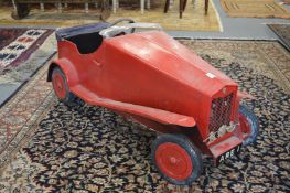 An early red painted metal pedal car.