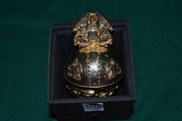 A gilt orb shaped memory stick holder.