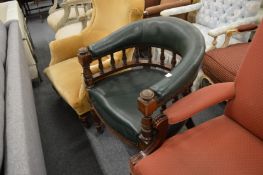 A Victorian horseshoe shaped armchair with green leather cloth upholstery.