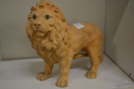 A terracotta model of a lion with glass eyes.