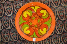 A Poole pottery orange glazed Delphis circular dish.