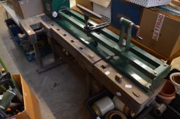 An old wood working bench on stand.