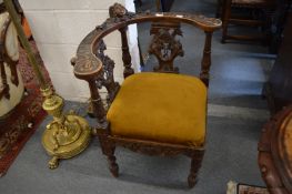 A 19th century corner armchair with carved decoration.