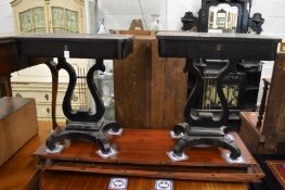 A pair of ebonised work tables with lyre shaped supports.