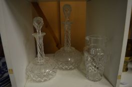 Two cut glass decanters and a cut glass jar.