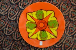 A Poole pottery orange glazed Delphis circular dish.