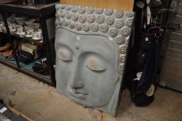 A large moulded resin face of Buddha.