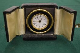A Looping travelling or bedside clock in fitted leather case.