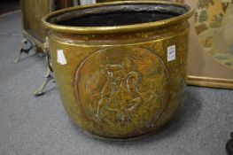 An embossed brass coal bucket.