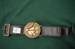 A brass compass with leather wrist strap.