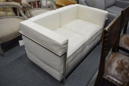 A stylish chrome framed cream upholstered two seater Art Deco style settee.