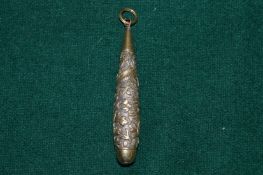 An engraved silver pendant.