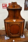 A small walnut hanging corner cabinet.