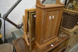 A pine cupboard and two dressing table mirrors.